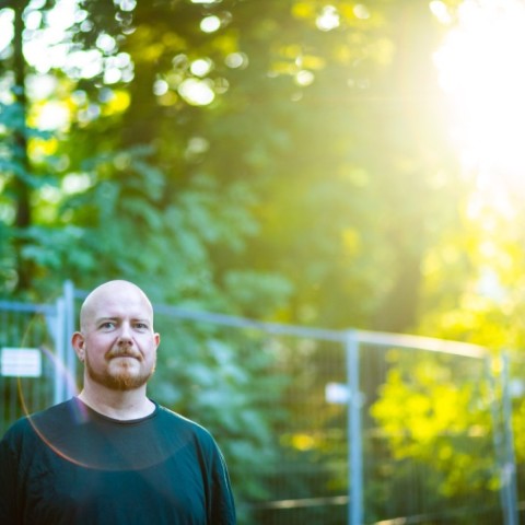 Daniel Seitz with red beard in front of trees and sunlight
