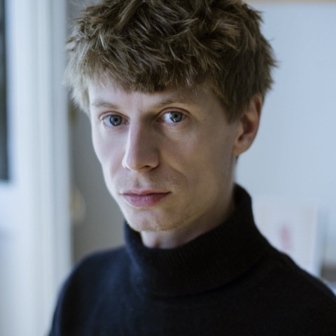 Julius Hackspiel with blond hair dressed in black looking straight at you