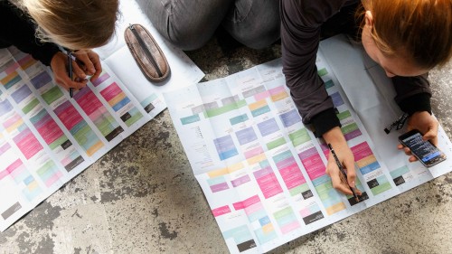 Teilnehmende der rp19 über den Programmplan gebeugt, markieren sich interessante Sessions.