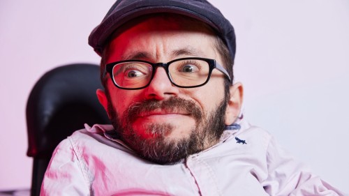 Raul trägt kurze Haare, eine dunkle Schiebermütze und ein helles Hemd.