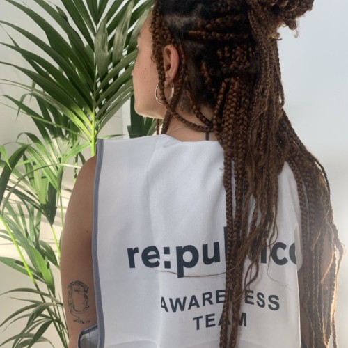 Bild zeigt den Rücken einer Person, die eine weiße Awareness Weste trägt auf der 're: publica - Awareness Team' steht