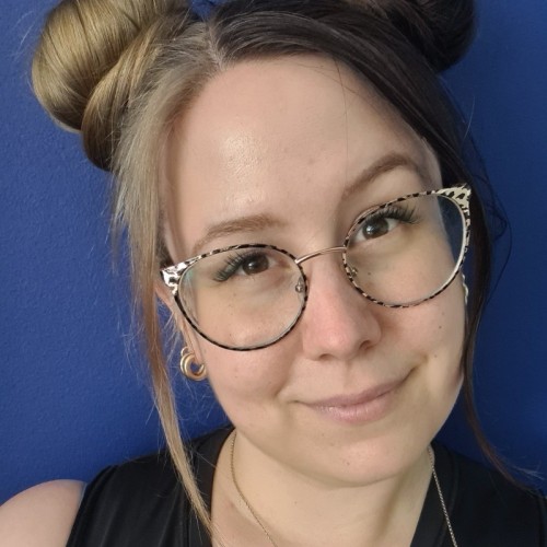 A picture of Ann-Kathrin, with glasses and half hair blonde half hair black, smiling.