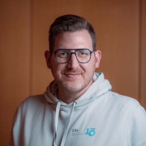 Portrait von Dirk Schoemakers, er trägt einen hellblauen D64 Hoodie.