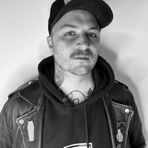 Alter weißer Mann. Trägt basecap und lederjacke um von seinem voranschreitenden Alterungsprozess abzulenken. Bild in Schwarz/Weiß
