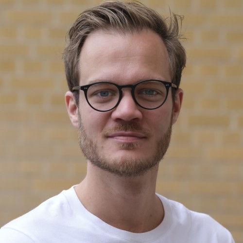 30 years old man with blonde hair, glasses and a white t-shirt