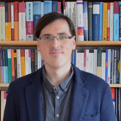 Portrait von Samuel Greef vor Bücherregal