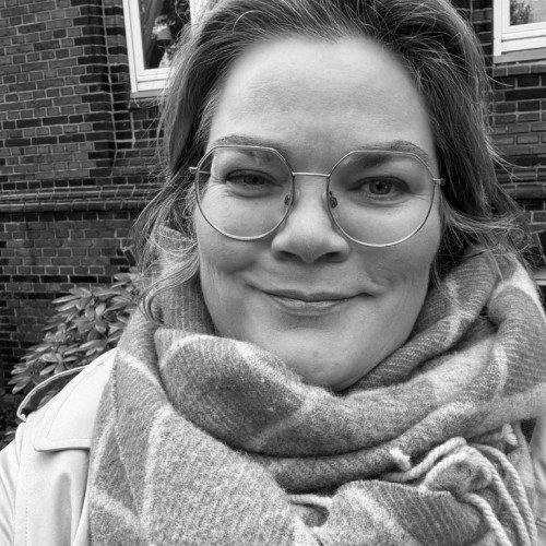 freundliches smartes Gesicht mit Brille und einem großen warmen Schal