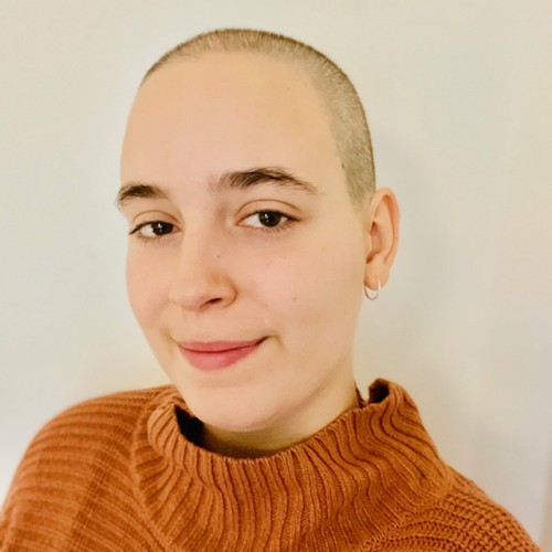 Person mit kurzen Haaren und braunem Pulli