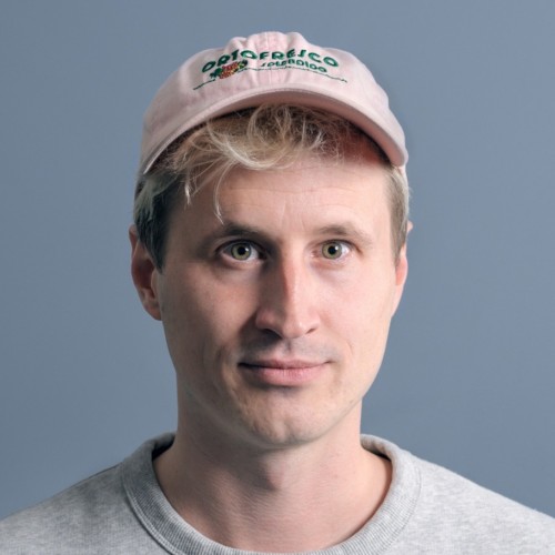 Ein Mensch mit rosa Cappy schaut direkt in die Kamera