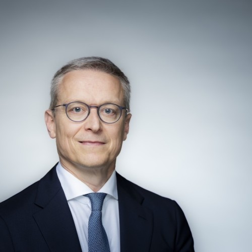 Mann mit Brille vor grauem Hintergrund