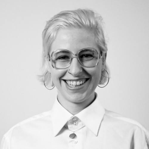 Black and White Portrait of a woman with a wide smile and big glasses.