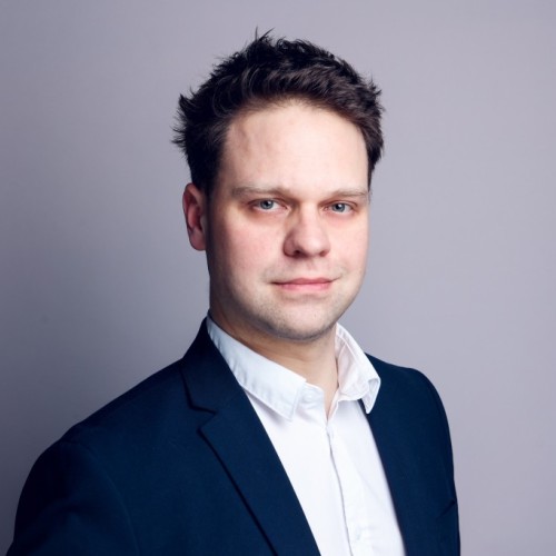 Portraitfoto von Maximilian Wehage vor grauem Hintergrund