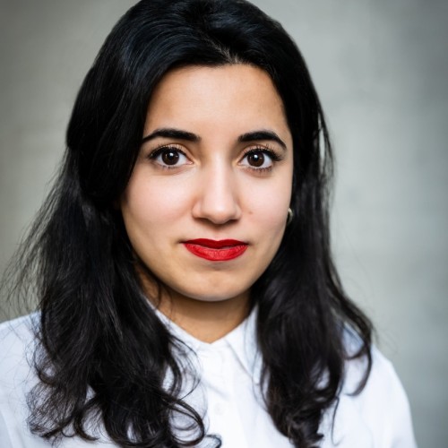 Portrait von Misbah Khan. Sie schaut direkt in die Kamera und trägt ein weißes Oberteil.