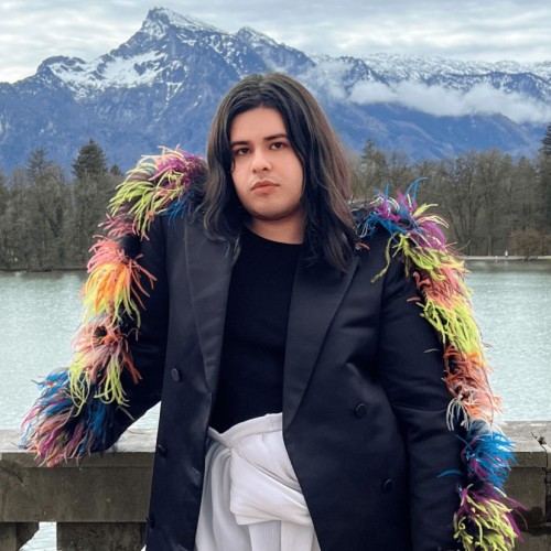 An image of a person wearing a coat with colored feathers.