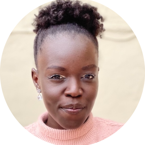 This picture features a woman of African descent with short natural hair, in a pink cardigan
