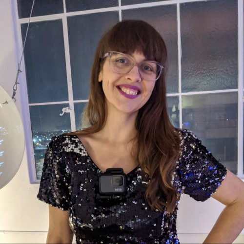 femme white person in glasses wears a gopro and sequin dress