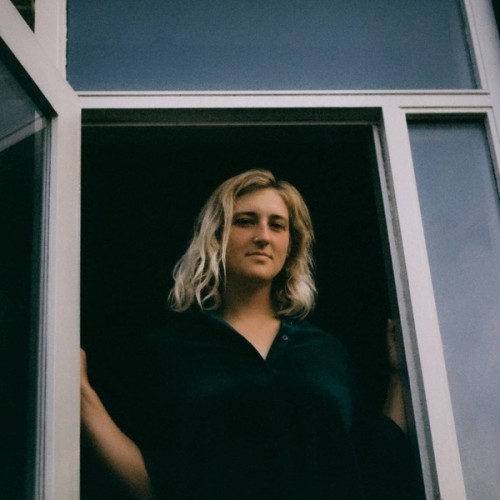 Irma standing in doorway, smiling softly.
