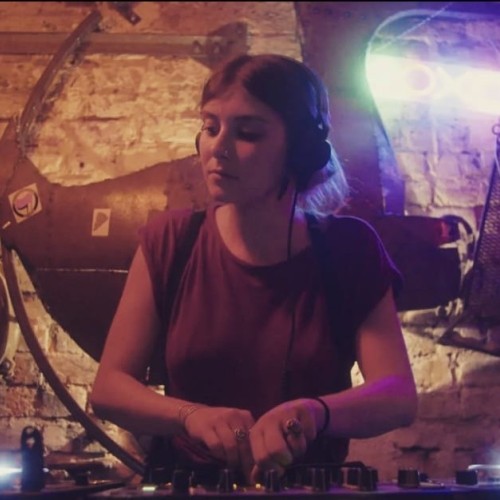 A picture of Dj Ferniture on the decks playing music, with a giant duck in the background.