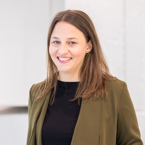 Porträt von Melanie mit schwarzem Shirt und grünem Blazer