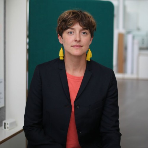 Person mit kurze Haare und gelbe Ohrringe