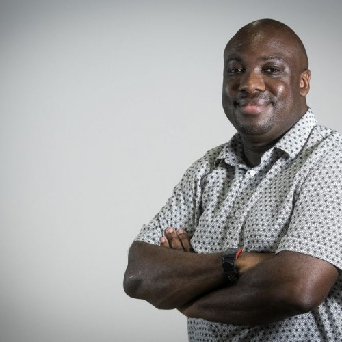Ian Forrester profile picture looking left with his arms crossed and spotty white shirt